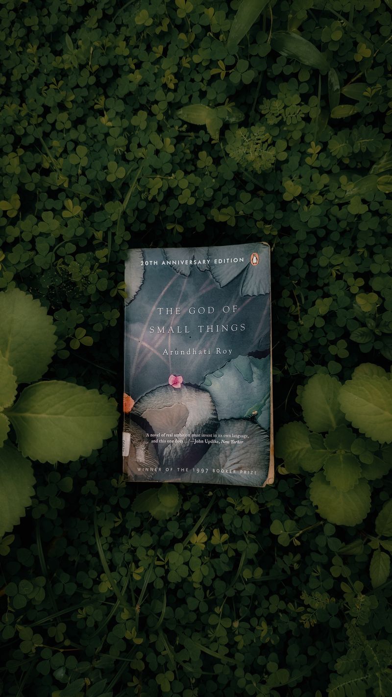 The God of Small Things book by Arundhati Roy on green leaves