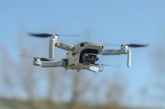 Aerial capture of a modern drone in flight against a clear blue sky, showcasing technology.
