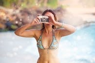 一名穿着比基尼的女子用老式相机在斯里兰卡乌纳瓦图纳的海滩上捕捉回忆