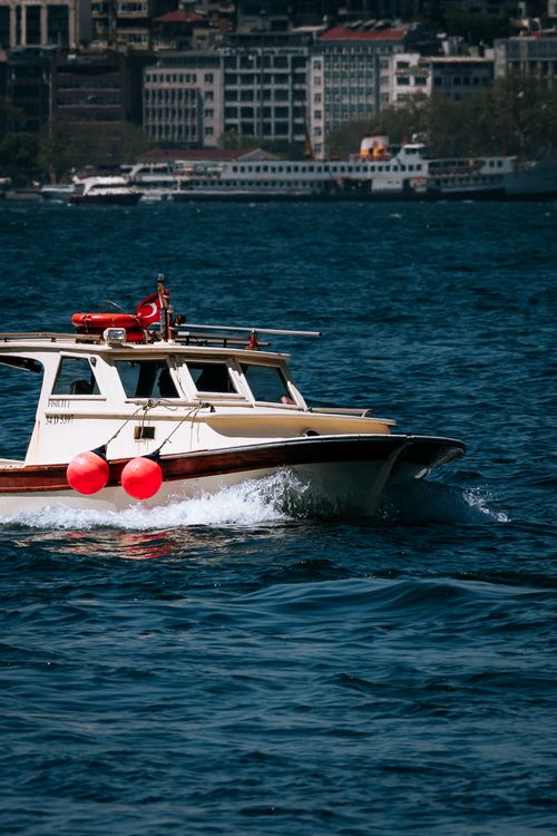 Free A boat navigates the vibrant Bosphorus waters in Istanbul, Turkey, with a cityscape backdrop. Stock Photo