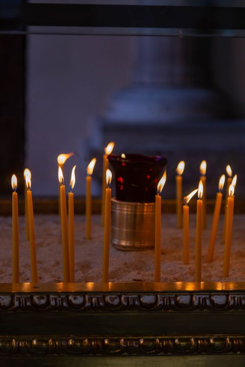 Free Peaceful votive candles lit in a dimly lit Istanbul church providing warm ambiance. Stock Photo