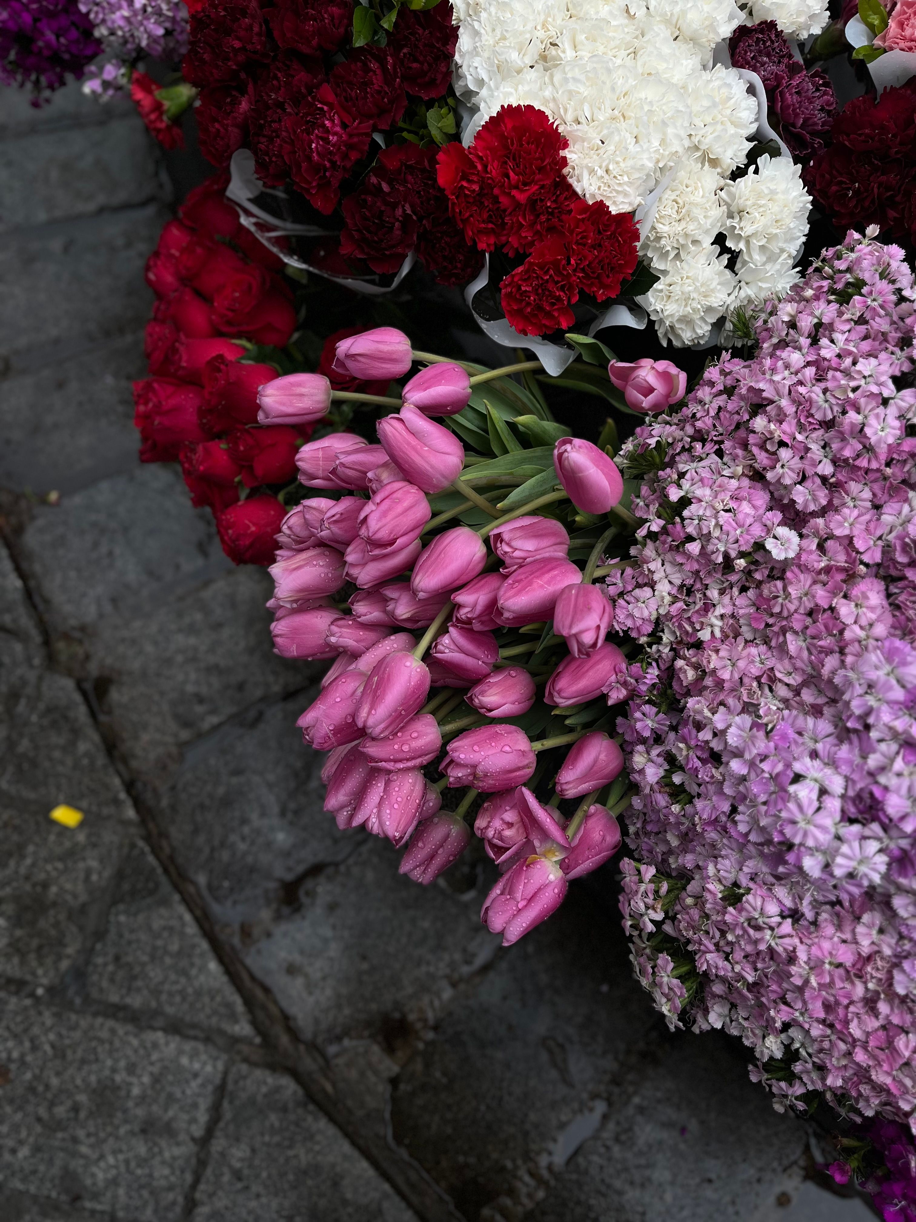 [ColoSach]-colorful-bouquets-of-tulips,-carnations,-and-hydrangeas-on-cobblestone-street-pavement.