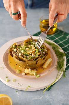 Close-up of a gourmet artichoke dish being prepared on a plate.