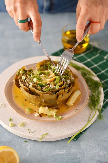 Close-up of a gourmet artichoke dish being prepared on a plate.