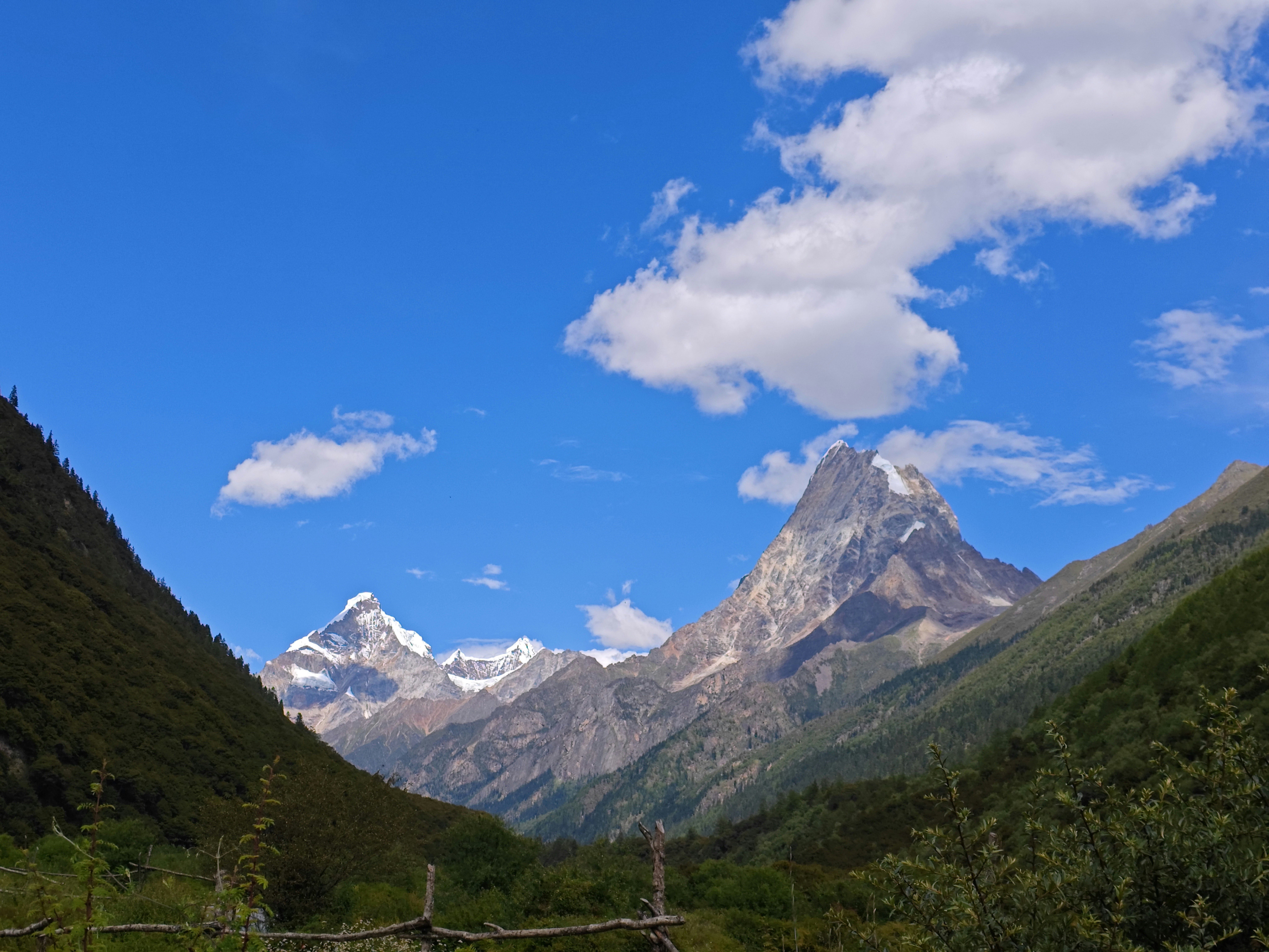 Fotomural Impresionante vista de las montañas tibetanas con picos nevados y cielos azules claros.