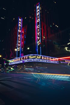Stunning night view of Radio City Music Hall in New York City showcasing vibrant neon lights.