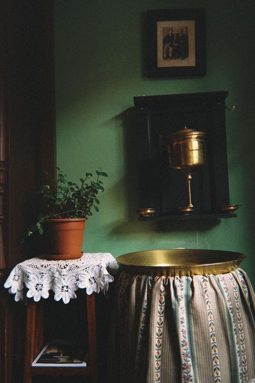Free Charming vintage corner with a potted plant and brass decor against a green wall. Stock Photo
