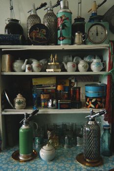 A nostalgic view of a cluttered kitchen shelf with vintage items.