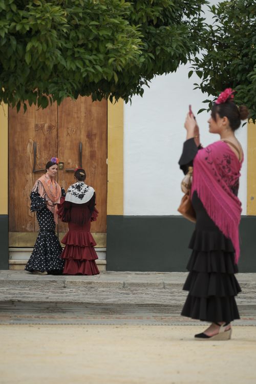 Free Women in flamenco dresses captured on a street in Seville, Spain, showcasing cultural attire. Stock Photo