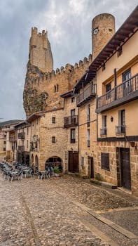 Charming cobblestone street with a medieval castle in Frías, Spain.