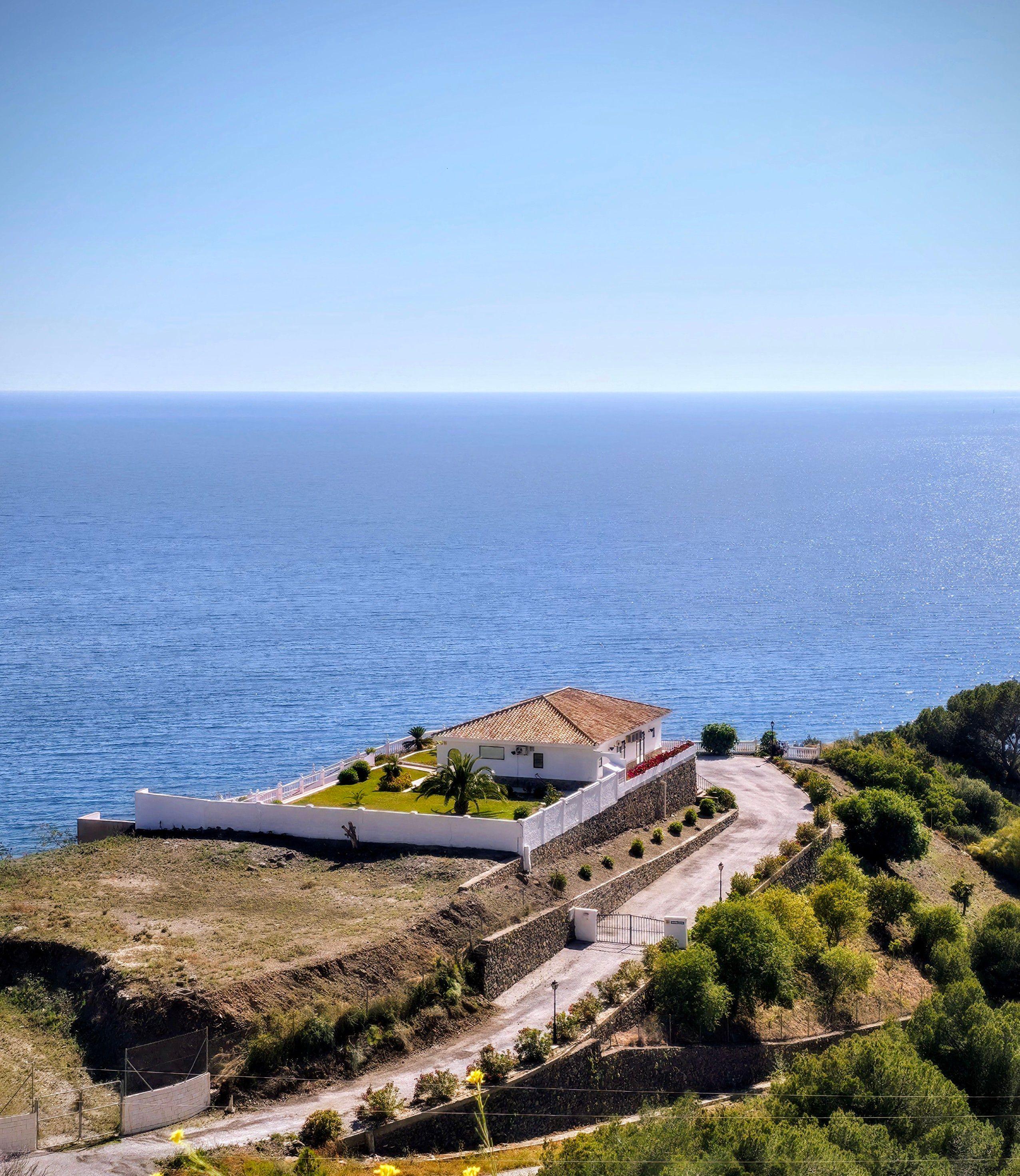 A picturesque house overlooking the vast ocean, offering serene coastal views.