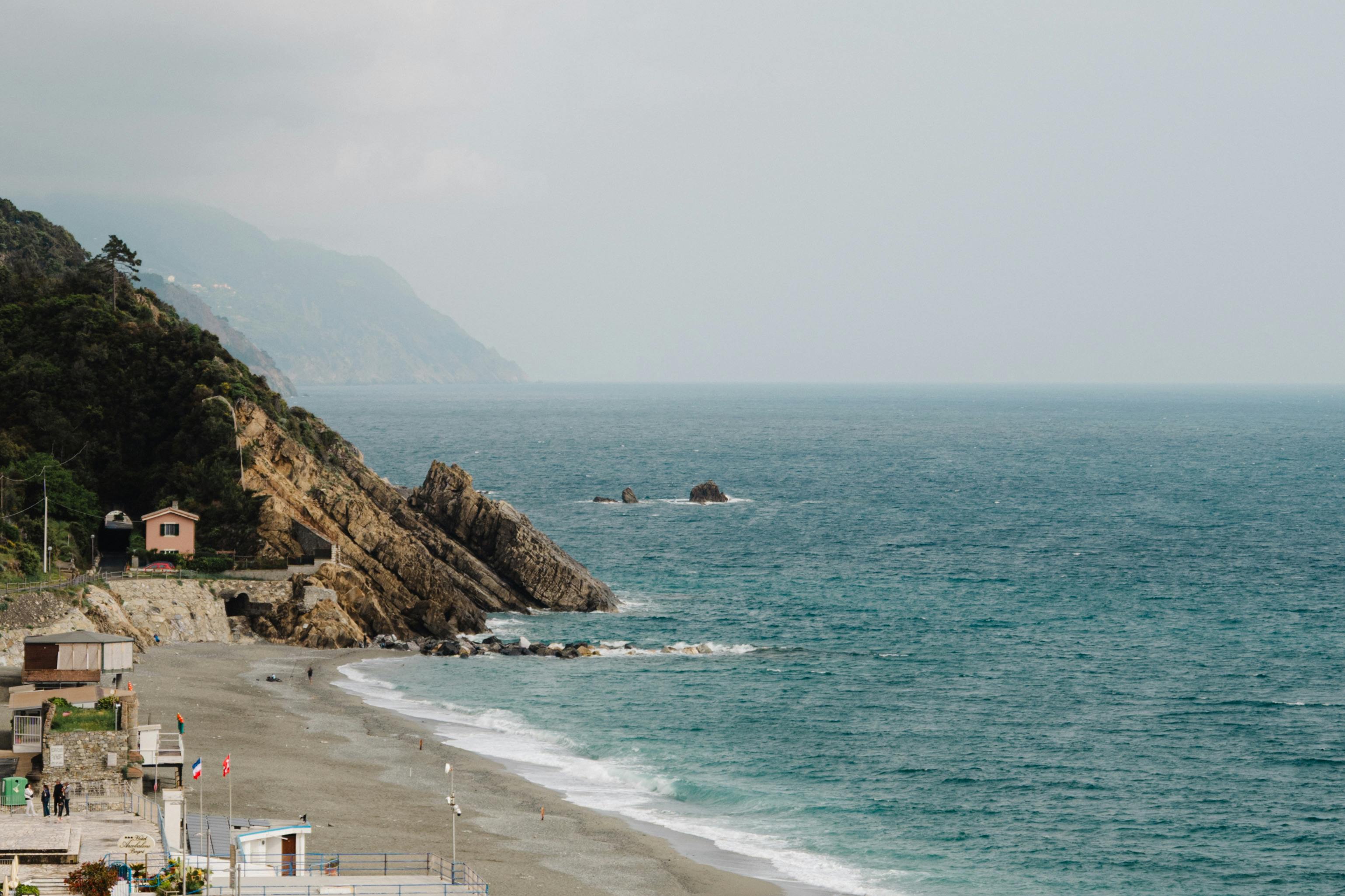 Breathtaking coastal view featuring rugged cliffs, vast ocean, and serene beach.