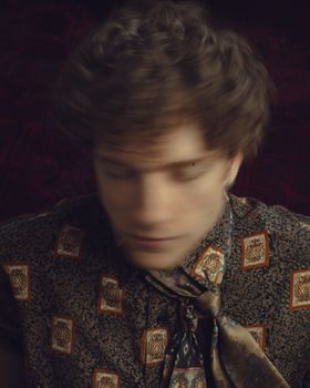 Blurred artistic portrait of a person wearing vintage patterned clothing, creating a nostalgic mood.