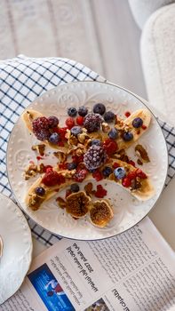 Healthy banana split with fresh berries, nuts, and figs. Perfect breakfast choice.