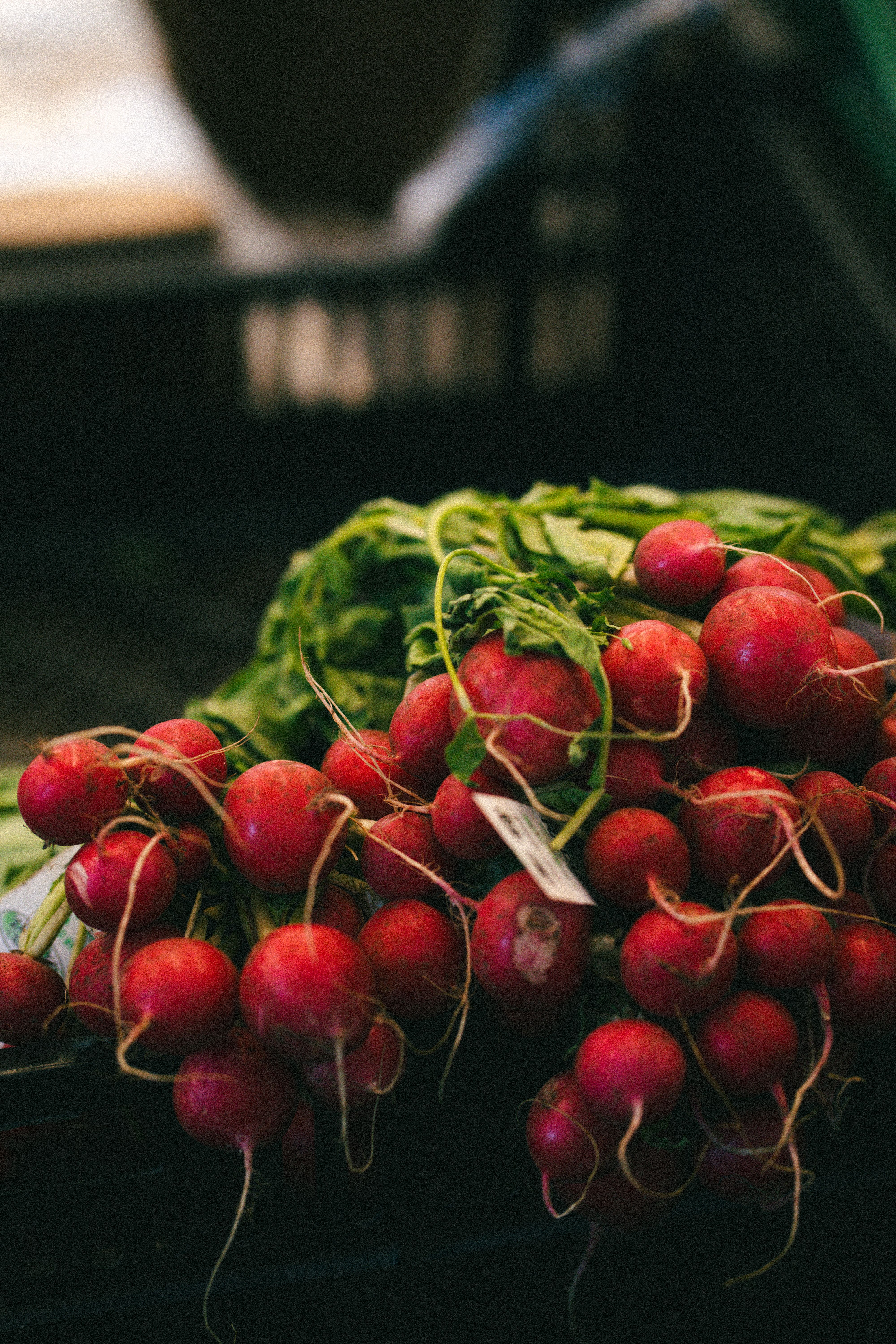A vibrant bunch of fresh red radishes displayed at a market stall.