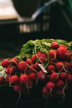 A vibrant bunch of fresh red radishes displayed at a market stall.