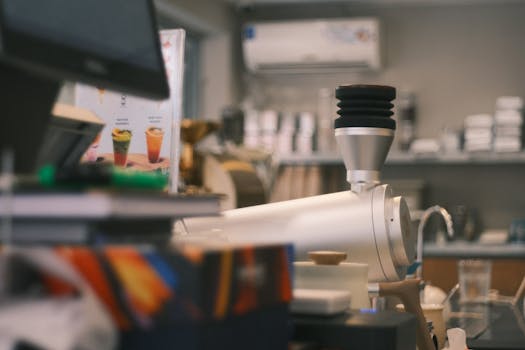 Contemporary coffee shop scene featuring a sleek espresso machine and blurred menu in background.