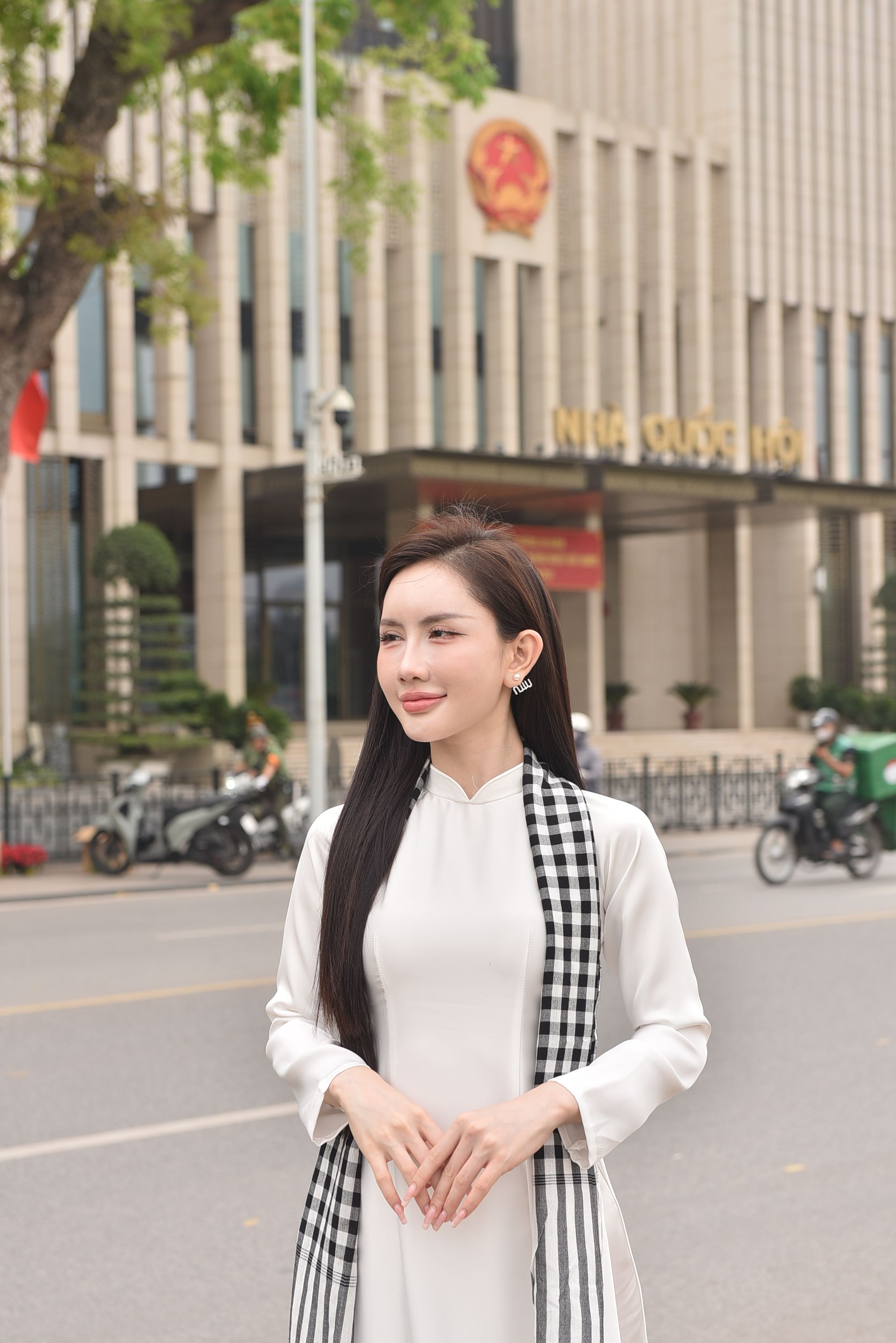Kostenlos Elegante Frau in traditioneller vietnamesischer Kleidung steht vor einem Wahrzeichen der Stadt. Stock-Foto