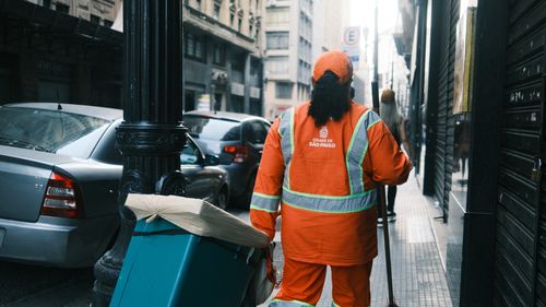 Free A street cleaner in São Paulo carrying cleaning equipment on a city street. Stock Photo