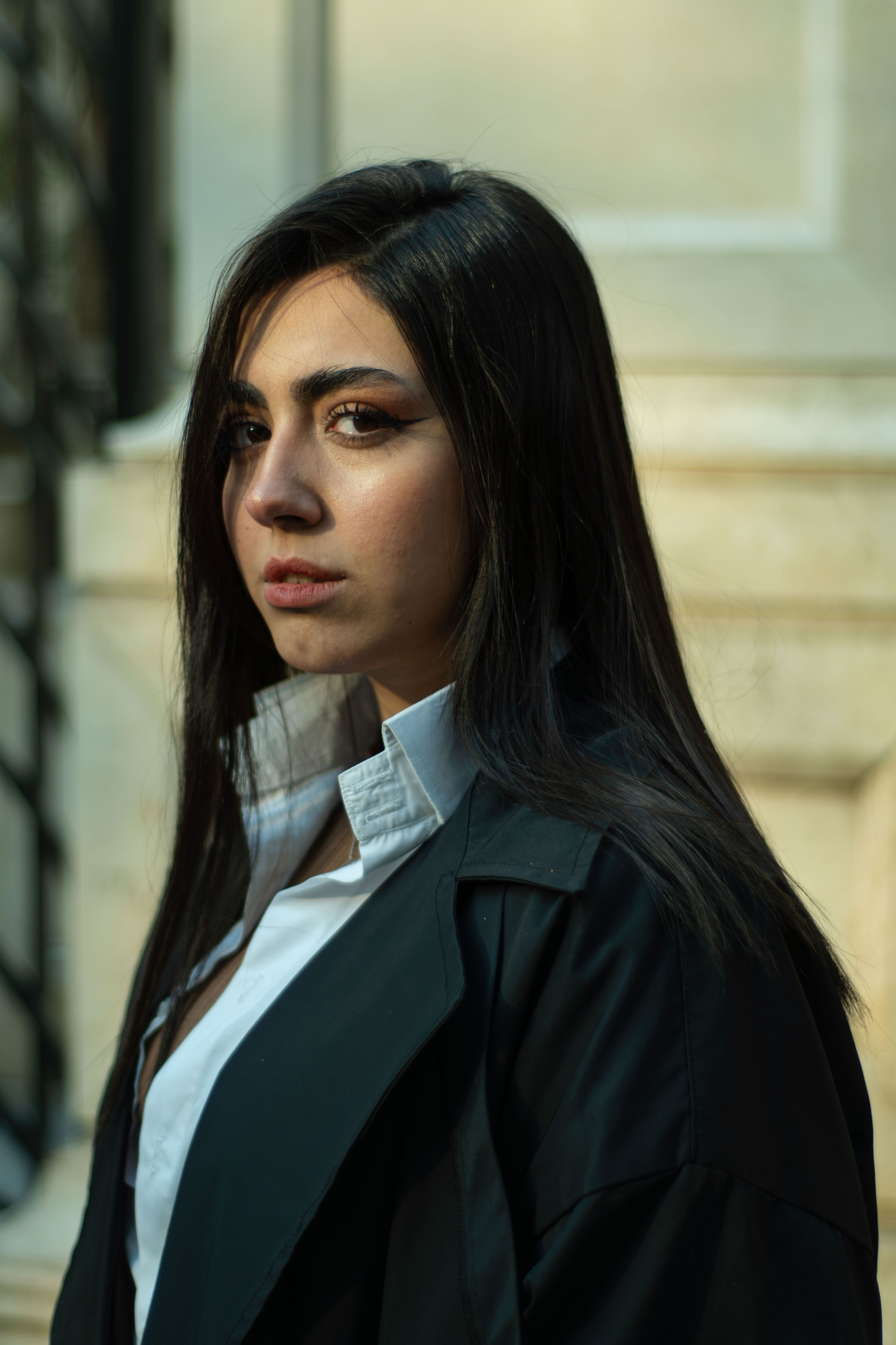 Portrait of a stylish woman standing outdoors in Tehran, exhibiting modern fashion.