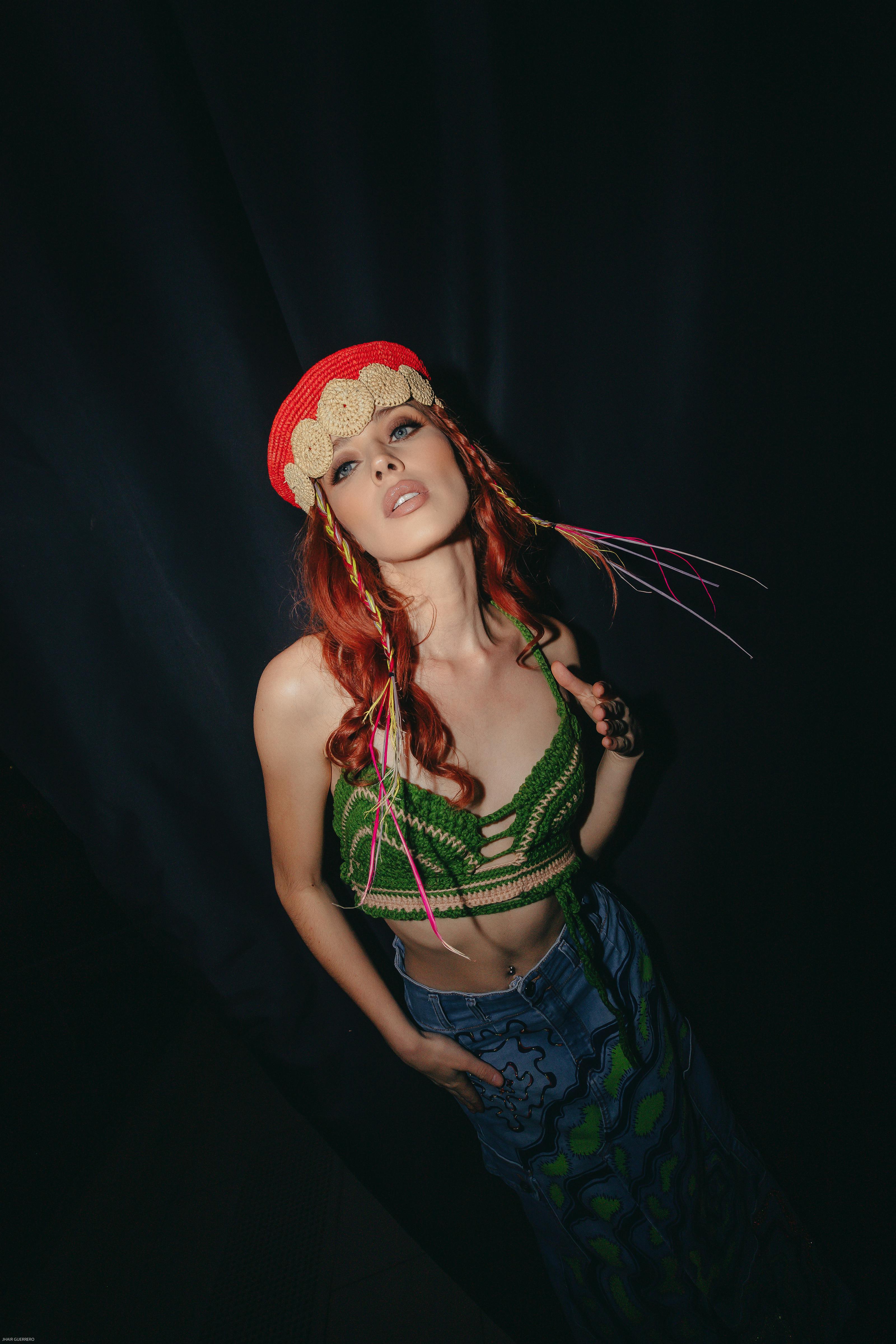 bezplatná Úchvatná modelka v zářivých šatech dramaticky pózuje uvnitř a předvádí tak moderní styl. Základová fotografie