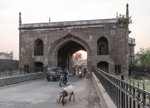 Traffic passing through a historic gate in Aurangabad, Maharashtra during daytime.