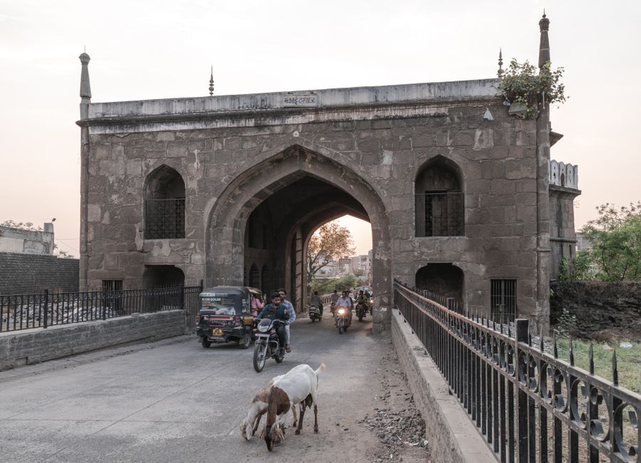 Traffic passing through a historic gate in Aurangabad, Maharashtra during daytime.