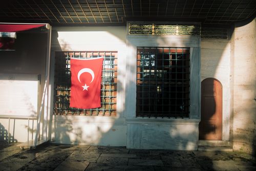 Free Sunlit Turkish flag on Ottoman architecture in Istanbul creates a serene ambiance. Stock Photo