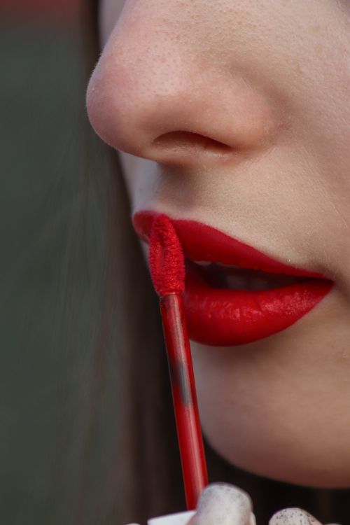 Free Detailed view of red lipstick being applied to lips, highlighting beauty and makeup techniques. Stock Photo