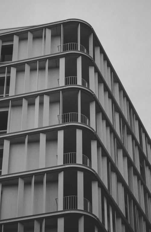Free Monochrome image of a modern building facade with clean lines and repetitive patterns. Stock Photo
