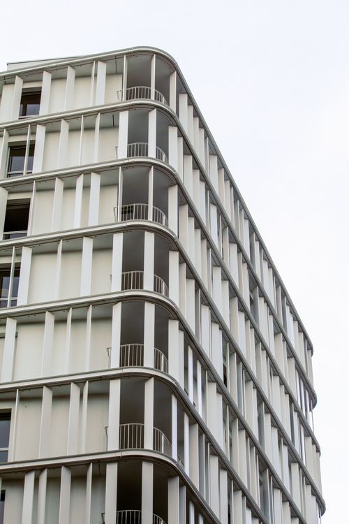 Free High-rise building with curved features and geometric facade in urban setting. Stock Photo