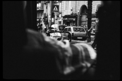 Free A black and white photo capturing a street scene with a reflection in a car mirror. Stock Photo