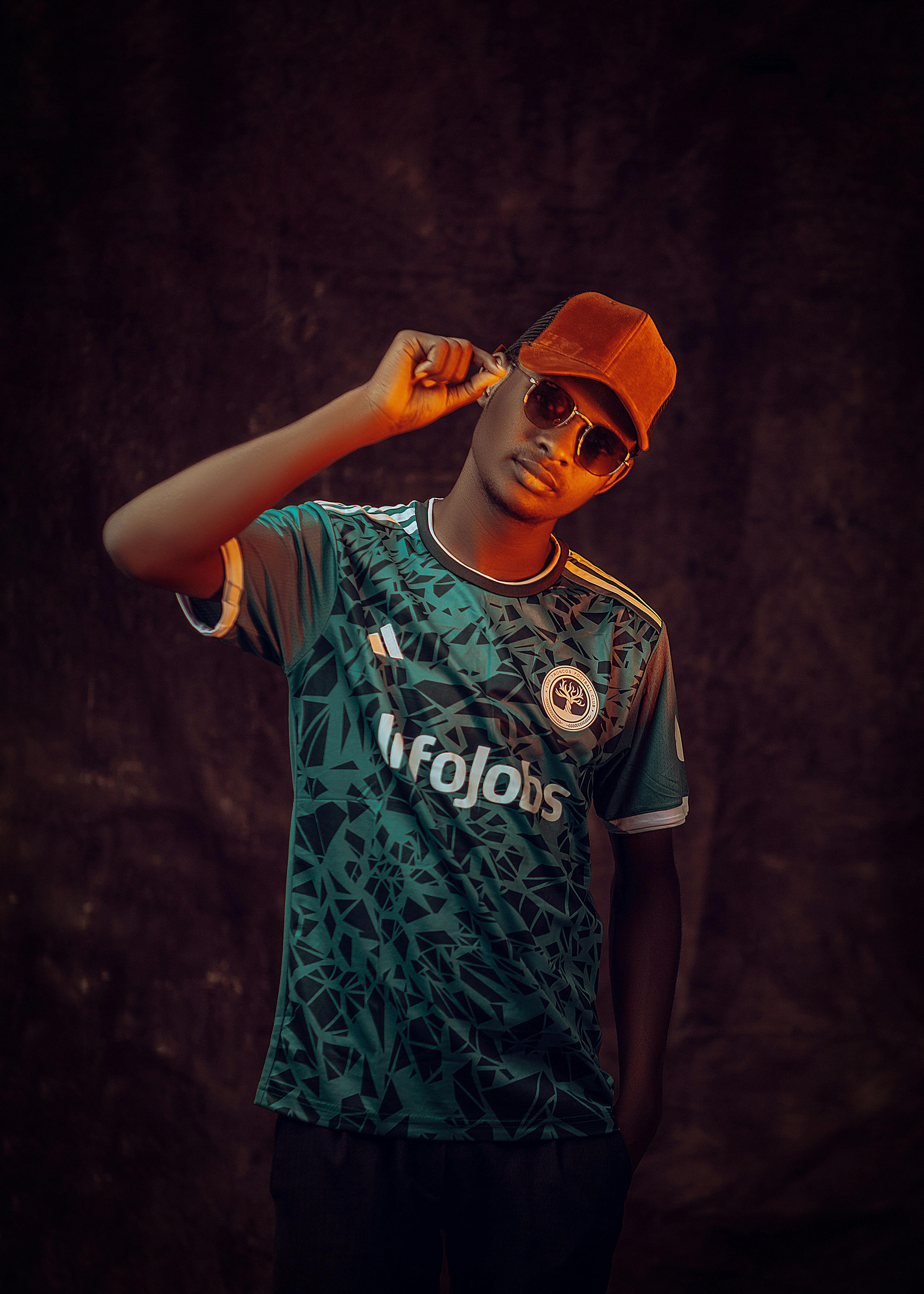 Portrait of a young man in sunglasses and cap, exuding urban style.