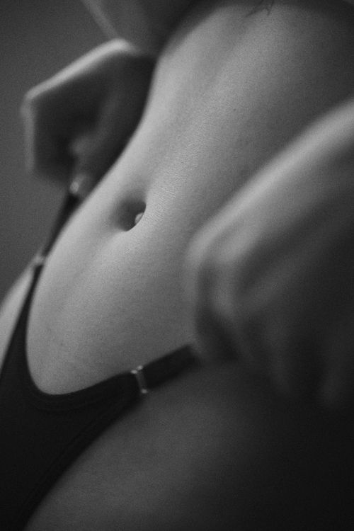 Free Artistic black and white image focusing on a woman's midsection. Minimalist and conceptual. Stock Photo