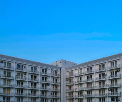 Symmetrical modern apartment building under a clear blue sky in Lucknow, India.