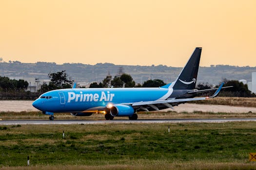 Prime Air cargo plane taxiing on runway during sunset, lush greenery surrounding.