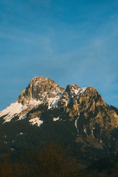 Stunning snow-covered mountain range with clear blue sky, ideal for nature and travel visuals.