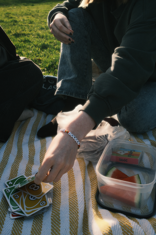 Free A relaxing picnic with card game on a sunny day with friends. Stock Photo