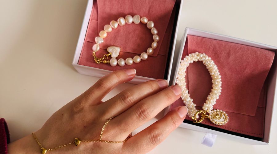 Bracelets dorés et perlés présentés dans des écrins ouverts pour un cadeau de fête des mères