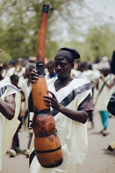 A man playing a traditional African instrument at a cultural festival in Nigeria, showcasing vibrant attire.