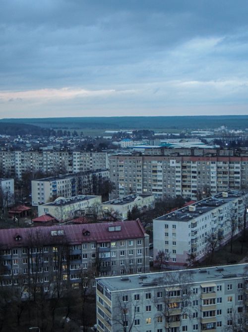 Free Overlooking a sprawling urban residential area at dusk with a moody sky. Stock Photo