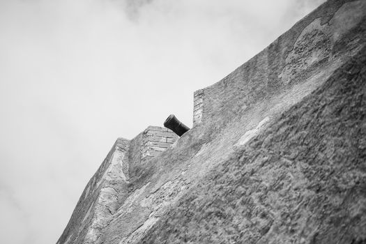 A black and white image of a historic cannon on El Jadida's fort wall in Morocco.