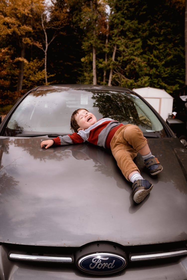 Photo Of Boy Lying Down On Car Hood