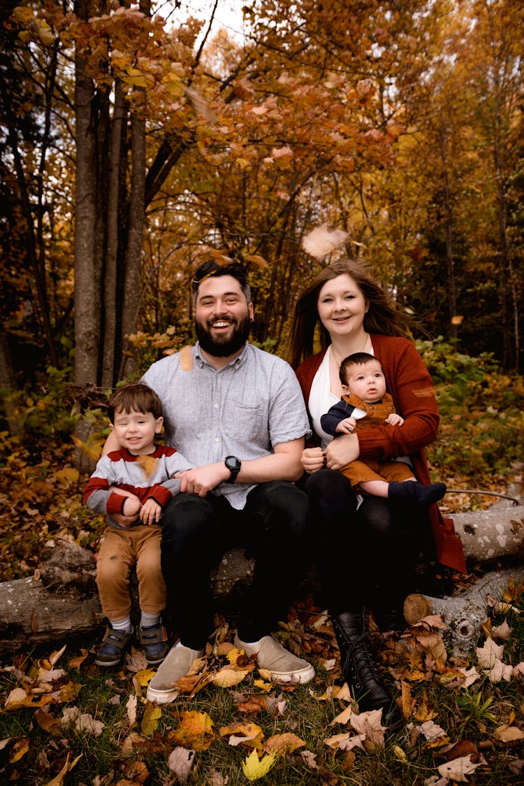 Photo Of Family Sitting On Tree Log