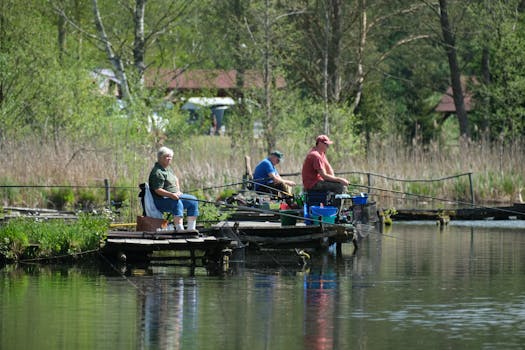 Adults fishing by a serene lake surrounded by lush greenery. Perfect outdoor relaxation scene.