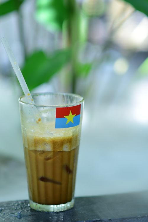 Free Refreshing iced coffee in a glass with a Vietnam flag sticker on a sunny day. Stock Photo