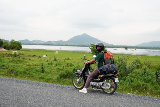 A traveler on a motorcycle explores the scenic countryside of Kampot, Cambodia.