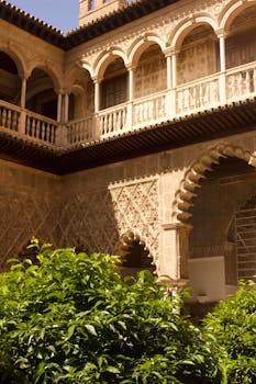 Stunning Andalusian architectural courtyard in Granada with intricate arches and lush garden.