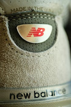 Macro shot of New Balance shoe logo and texture showing branding details.