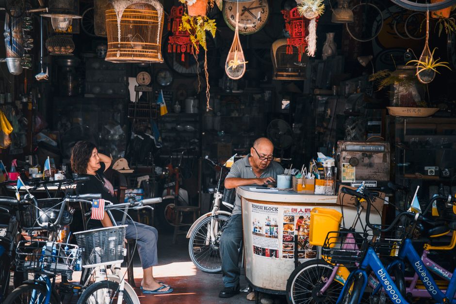 A bustling vintage bicycle shop with busy locals, set in an eclectic urban marketplace filled with old-world charm.